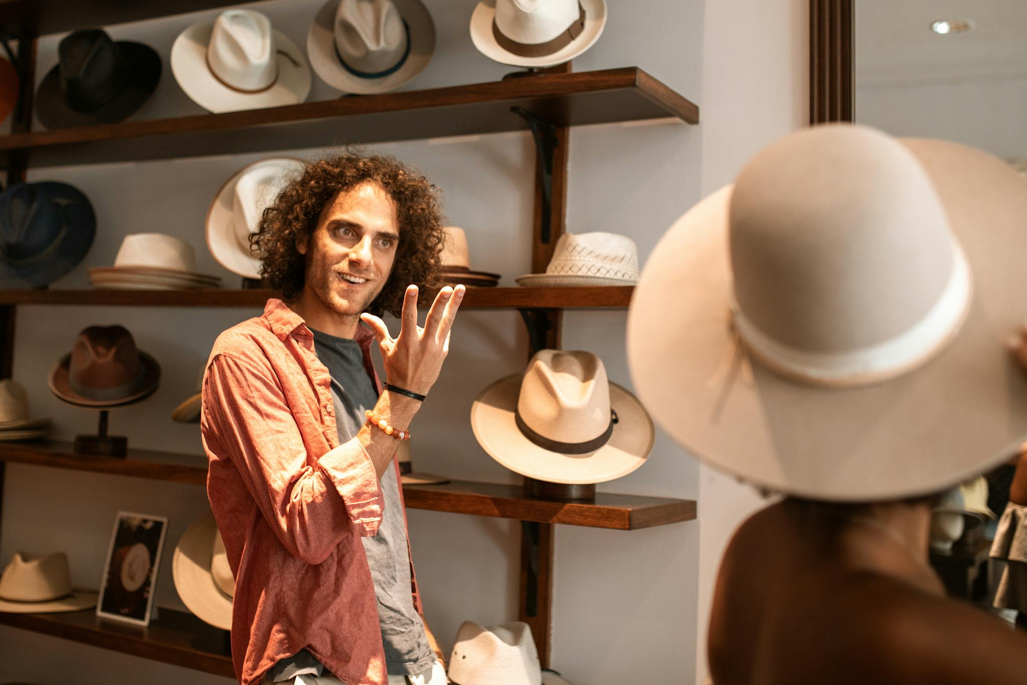 A stylish couple in a boutique browsing and trying on hats. Fashionable shopping scene.