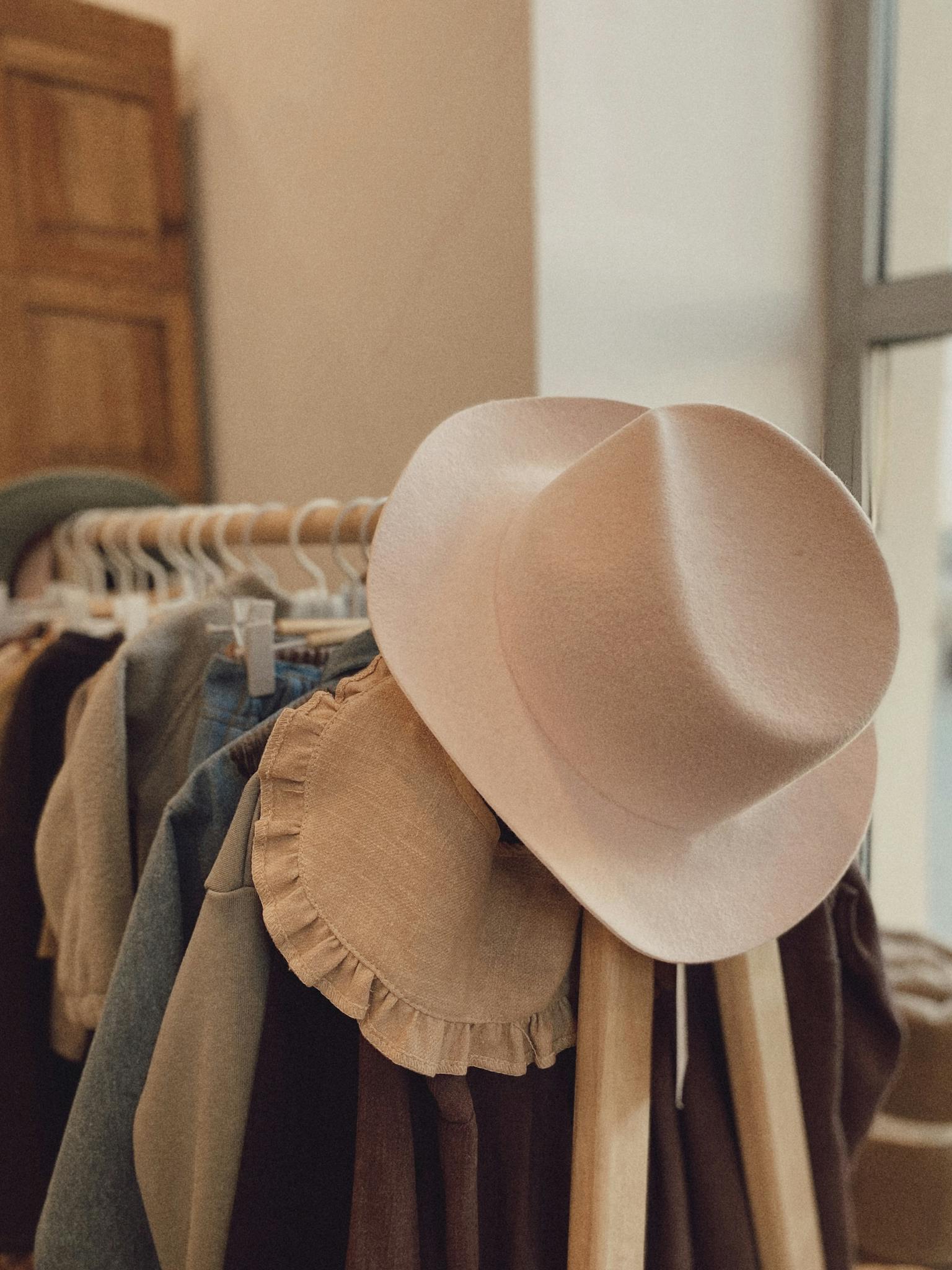 An artistic display of fashionable clothes and a stylish hat on a rack, perfect for lifestyle and fashion themes.